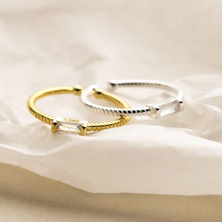 Top-down view of the gold and silver sterling silver rings with sparkling rectangular crystals.