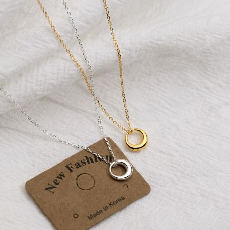 Collar colgante hueco minimalista de plata esterlina 925. - Un conjunto de collares colgantes huecos minimalistas en acabados de oro y plata, elaborados con plata esterlina 925, exhibidos en una etiqueta de 'Nueva Moda'.