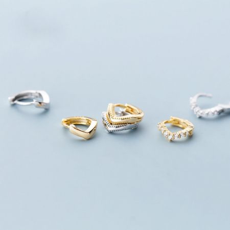 Aretes huggie helix en forma de V de plata esterlina pequeños y delgados. - Una colección de aretes huggie helix en forma de V de plata esterlina, exhibidos en acabados de oro y plata y en varios estilos.