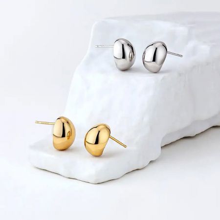 Orecchini a perno a forma di fagiolo piccolo francese in argento sterling 925 (5 paia) - Un paio di orecchini a perno a forma di fagiolo piccolo in oro e un paio in argento 925 sterling francese esposti su uno sfondo bianco, mostrando il loro design minimalista.