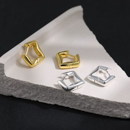 Gouden Geometrische Creolen 925 Zilver Wit Goud Verguld Groothandel - Een paar moderne geometrische creolen in zowel 18K verguld als 925 sterling zilveren afwerkingen, naast elkaar weergegeven op een schone witte achtergrond.