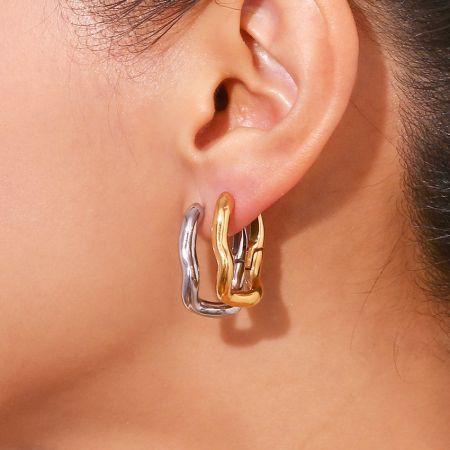 Model wearing the stainless steel rectangular huggie hoop earrings in a stylish, layered look.