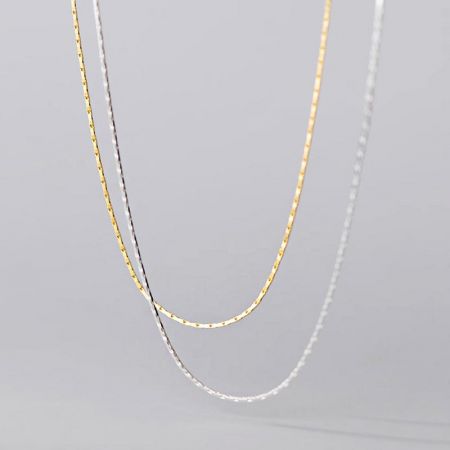 Collier en chaîne serpent super fin en argent sterling 925 en gros - Un gros plan du produit des colliers en chaîne serpent super fins en argent sterling 925, mettant en avant les finitions en or et en argent ainsi que leur texture délicate.
