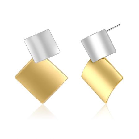 Dettaglio ravvicinato del design metallico misto sugli orecchini geometrici a doppio quadrato.