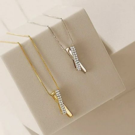 Collar de cruz de plata esterlina 925. - Un collar de cruz de plata esterlina 925 mostrado en acabados de plata y oro, adornado con brillantes piedras de circonita.