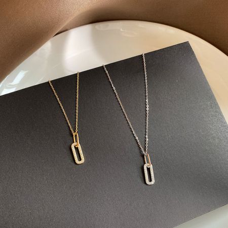 Collar con colgante ovalado mini pavé de zirconia CZ en plata esterlina 925. - Un conjunto de collares con colgante ovalado mini pavé de zirconia CZ en plata esterlina 925, mostrando las opciones de acabado en oro y plata en una tarjeta de exhibición.