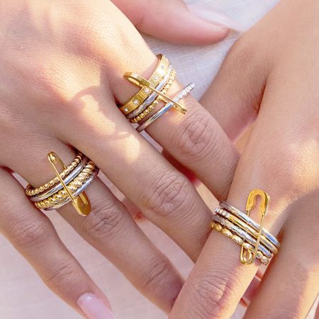 A model's hands displaying a stylish set of two-tone stackable stainless steel rings.