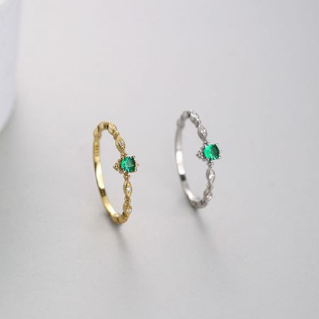 Detailed view of the intricate bands on the gold and silver emerald zircon rings.