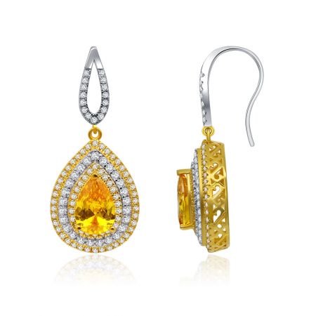 Vista dettagliata della lavorazione in metallo bicolore oro e argento sugli orecchini a goccia in topazio giallo, evidenziando l'intricato incastonamento delle gemme.