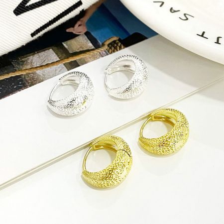 Orecchini a cerchio spessi a forma di borsa in argento sterling 925 testurizzati - Un paio di orecchini a cerchio spessi a forma di borsa in oro e un paio in argento sterling 925 testurizzati esposti fianco a fianco.