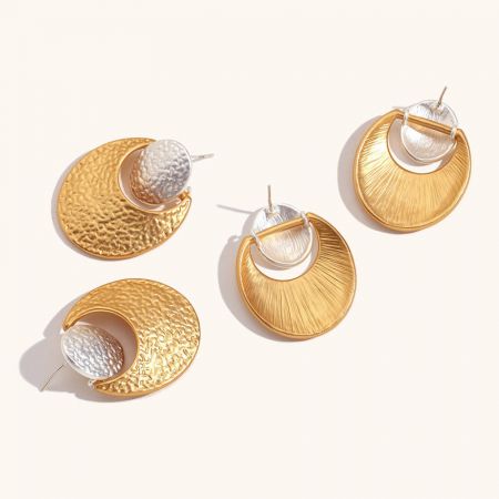 Pendientes geométricos de acero inoxidable bicolor martillados (Juego de 5 pares) - Un par de pendientes geométricos de acero inoxidable con un diseño bicolor, que presenta una luna creciente martillada en oro unida a un arete circular de plata, mostrado sobre un fondo blanco.