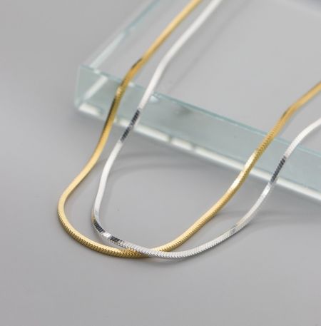 Cadena de serpiente plana de plata esterlina 925 - Una exhibición que muestra la cadena de serpiente plana de plata esterlina 925 en acabados plateados elegantes y dorados lujosos.