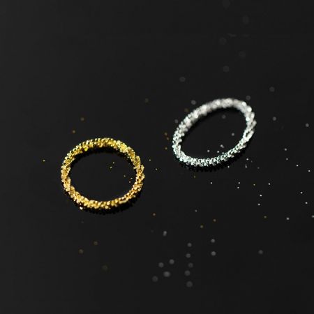 Detailed view of the textured gold and silver rings.
