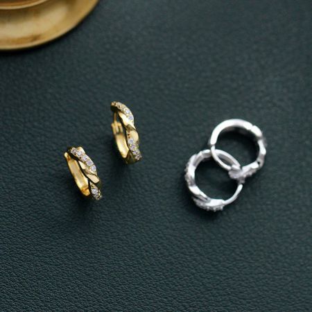 Elegante Twist - 925 Sterling Zilveren Gebogen Zirkonia Oorbellen (5 paar) - Een paar gouden en een paar zilveren Elegant Twist 925 sterling zilveren gebogen oorbellen met sprankelende zirkonia stenen, weergegeven op een schone witte achtergrond.