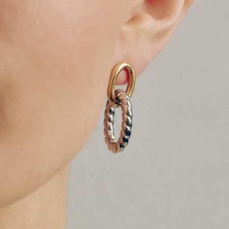 Stylish two-tone oval twist stainless steel hoop earrings in gold and silver.