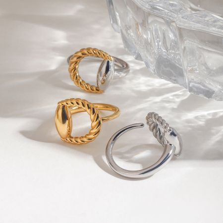 Primo piano del design a corda attorcigliata bicolore oro e argento sugli anelli in acciaio inossidabile.
