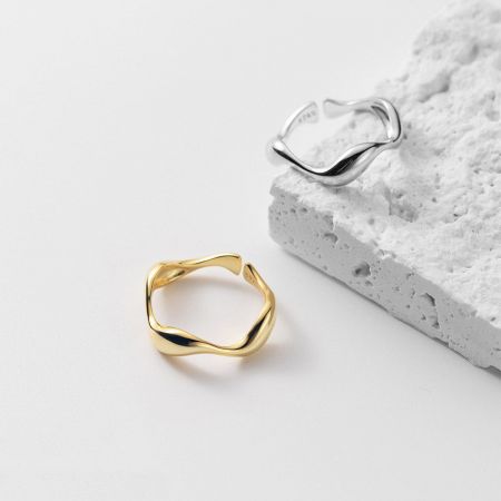 Set di 5 anelli ondulati regolabili in argento sterling 925 irregolari. - Un set di due anelli ondulati regolabili in argento sterling 925, uno placcato in oro e l'altro in argento, esposti su uno sfondo bianco pulito.