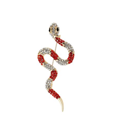 El elegante broche de serpiente dorada adornado con una mezcla de piedras preciosas rojas y claras.