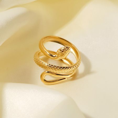 Gedetailleerde studio-opname van de gouden slangvormige ring, die de textuur en vorm benadrukt.