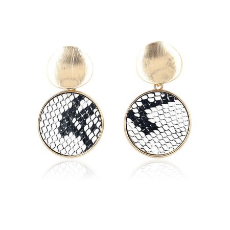 Gros plan de la boucle d'oreille montrant le dessus en or brossé et le motif en cuir de serpent noir et blanc.