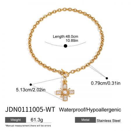 The chunky gold stainless steel cross necklace with pearl and crystal pendant displayed on a fashion newspaper background.