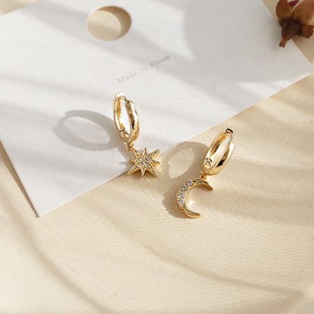 Detailed view of the gold star and crescent moon earrings with a unique textured finish.