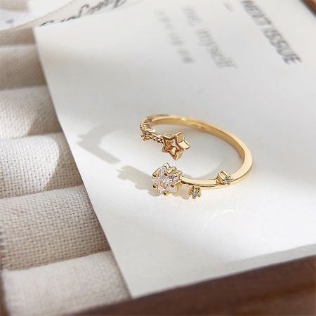 Primer plano de un anillo chapado en oro con un diseño único de estrella y diamante.