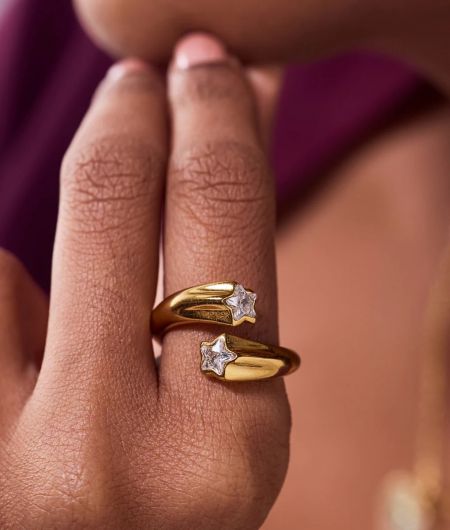 Model wearing the stackable gold star rings to showcase their stylish fit.
