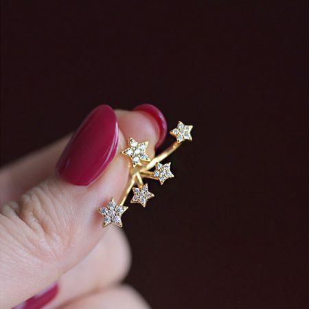 Primo piano dettagliato di un singolo orecchino a stella placcato oro che mette in mostra la pietra zirconia.