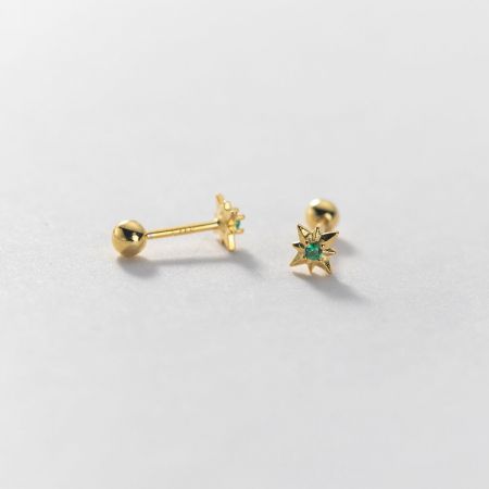 A pair of gold star-shaped earrings highlighting a rich green gemstone.