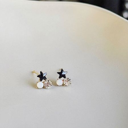 パールとクリスタルビーズの精巧なディテールを強調した金のスターピアスのクローズアップビュー。
