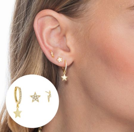 Modelo mostrando el uso elegante del conjunto de pendientes de estrella dorada y rayo.