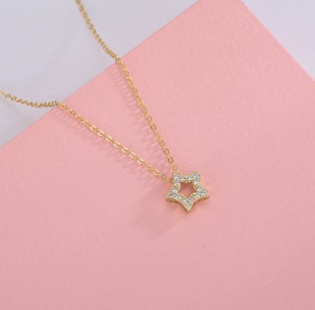 Collar de estrella de plata esterlina 925 - Un primer plano detallado del collar de estrella de plata esterlina 925, con un colgante de estrella chapado en oro engastado con brillantes piedras de circonio cúbico blancas.