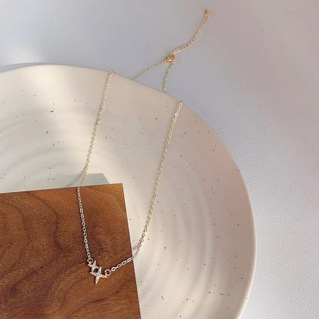 The double-star necklace elegantly displayed on a decorative surface.