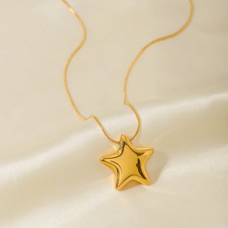 Gedetailleerd uitzicht op de gouden PVD-geplateerde sterhanger aan zijn slangenketting.