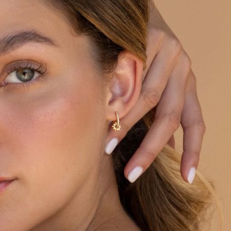 Model wearing the gold star huggie earring, showcasing its elegant sparkle.
