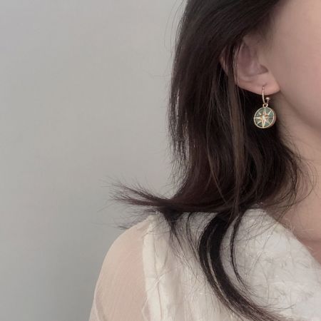 手作りのレジンと金メッキのイヤリングのクローズアップ。