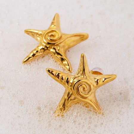 Detailed view of the gold star earrings, showing the intricate spiral design at the center.