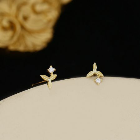 Gedetailleerde opname van de gouden kleine zircon bloemenstud oorbel, met de schitterende centrale zirconsteen.