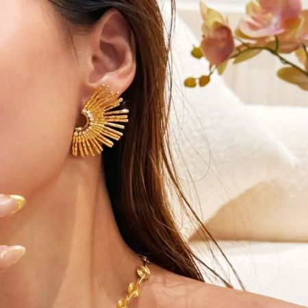 El pendiente de botón de girasol mostrado junto a un collar de cuerda retorcida para un look completo.