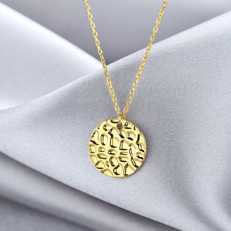 Collar de disco de moneda con textura martillada geométrica de plata esterlina 925. - Primer plano de un collar de plata esterlina 925, chapado en oro, con un colgante de disco de moneda geométrico con una textura martillada distintiva.