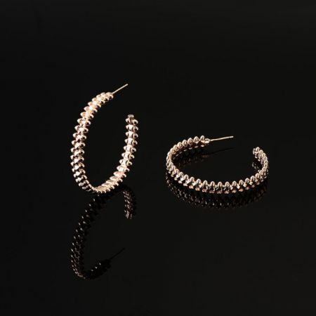 Un par de aretes de aro texturizados chapados en oro, que muestran una opción de color alternativa.