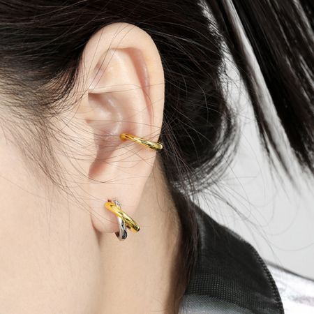 Uma modelo mostrando como os brincos de argola com nó bicolor podem ser estilizados para um look cotidiano e fashion.