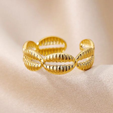 Een andere kijk op de elegante gedraaide gouden ring, onderdeel van de cowrie-schelp collectie.