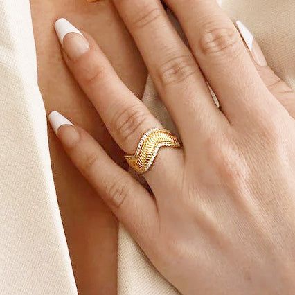 Modèle portant la bague ondulée en or à l'annulaire pour montrer l'échelle et le style.