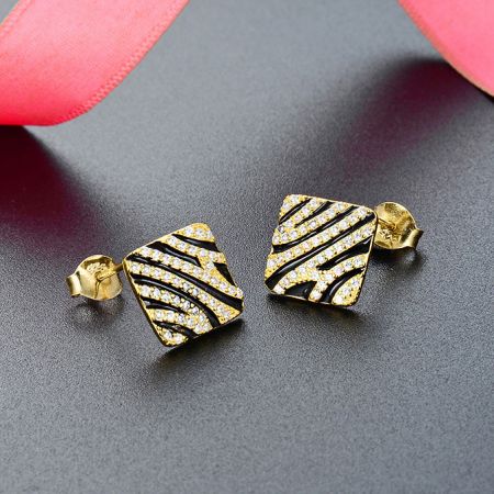 Orecchini a perno con motivo zebra placcati in oro in argento sterling 925 (5 paia) - Un paio di orecchini a perno in argento sterling 925 con un sorprendente motivo zebra placcato in oro, abbelliti con piccole pietre bianche, esposti su uno sfondo bianco.