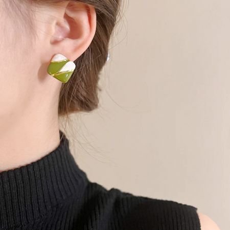 Vue de dessus des boucles d'oreilles carrées mettant en valeur les accents dorés.