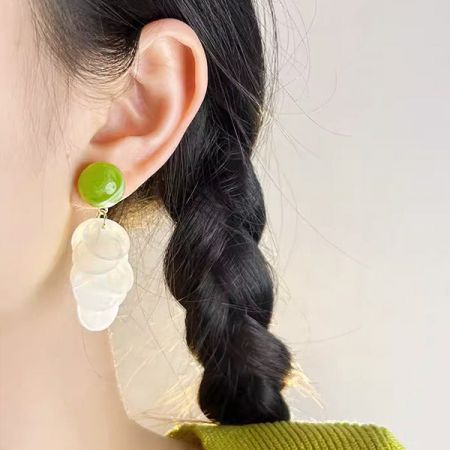 コレクションからの単一の緑と白のペンダントイヤリングの詳細ビュー。
