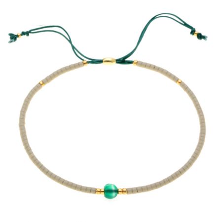Un elegante braccialetto in corda verde con accenti dorati e una perla verde centrale.