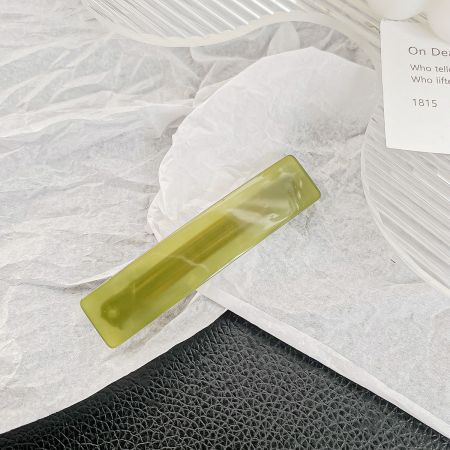 A single vibrant green rectangle hair barrette clip.